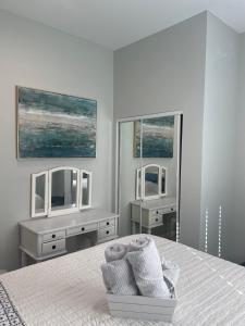 um quarto branco com 2 espelhos e uma cama em Van Nuys Luxury, near to Universal Studios, and Hollywood em Los Angeles