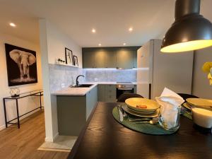 a kitchen with a wooden table with plates on it at Stay Inn Bergen Apartment in Bergen