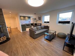 a living room with a couch and a kitchen at Stay Inn Bergen Apartment in Bergen