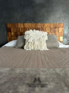 a bed with a blanket and pillows on it at Mare mío Hotel Boutique in Puerto Arista