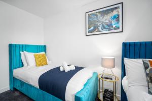 Un dormitorio con una cama azul y blanca con un animal de peluche. en Contractors & Families Delight - Spacious 3-Bed Accommodation Sleeps 7, Snooker Table, Smart TV, Netflix, Parking, Derby City Centre en Derby