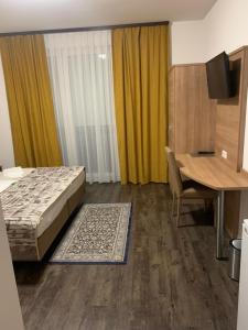 Schlafzimmer mit einem Bett, einem Schreibtisch und einem Tisch in der Unterkunft Hotel Pizzeria Da Beni in Kochersteinsfeld