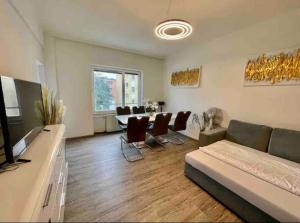 Una sala de estar con un sofá, una mesa y sillas. en Mozarts Salzburg City Retreat, en Salzburgo