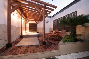 een houten terras met een bank en een tafel bij ホテル　Kirara in Kurosu