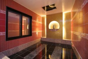 ホテル　Kirara في Kurosu: حمام به مرآة ومغسلة وبلاط احمر