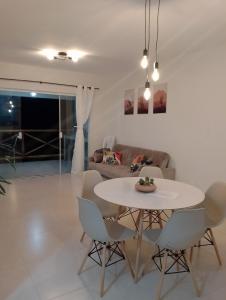 a living room with a table and chairs at Apartamento no Condomínio Vila das Águas in Estância
