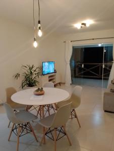 uma sala de jantar com uma mesa branca e cadeiras em Apartamento no Condomínio Vila das Águas em Estância