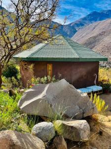een klein huis met een bank en een rots bij Aldea Biocultural Ayelen in Piedra Lisa