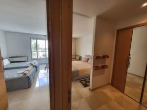- une chambre avec un lit et un miroir dans l'établissement joli appartement terrasse casablanca, à Casablanca
