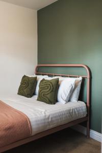 ein Bett mit einem Metallrahmen und Kissen darauf in der Unterkunft Wych Cottage, Striking 2 Bed, Parking, Ground Floor Flat - Step Free in Somerton