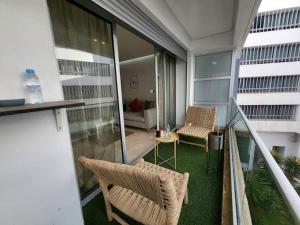 Cet appartement dispose d'un balcon avec deux chaises et une table. dans l'établissement joli appartement terrasse casablanca, à Casablanca