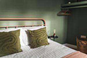 ein Schlafzimmer mit einem Bett mit zwei Kissen darauf in der Unterkunft Wych Cottage, Striking 2 Bed, Parking, Ground Floor Flat - Step Free in Somerton