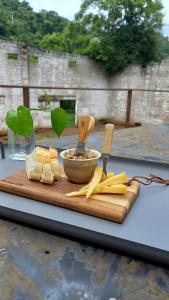 a cutting board with cheese and bread on a table at Pousada IMcasa 430 in Bento Gonçalves