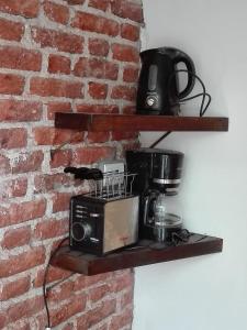 una cafetera en un estante junto a una pared de ladrillo en Casa del Bosque en Mar del Plata