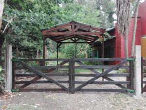 un cancello in legno con baldacchino in legno di fronte a un edificio di Casa del Bosque a Mar del Plata