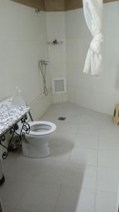 a white bathroom with a toilet in a room at RIYAD ZENAGA in Figuiq