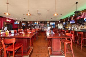 eine Bar mit Holztischen und -stühlen in einem Restaurant in der Unterkunft 6768 Collins Miami Stays in Miami Beach