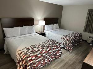 una habitación de hotel con 2 camas y una lámpara en Red Roof Inn Dunbar, en Dunbar