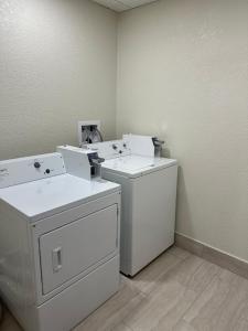 DunbarRed Roof Inn Charleston - Dunbar的洗衣房配有白色洗衣机和烘干机