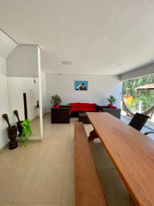 salon z drewnianym stołem i czerwoną kanapą w obiekcie Rancho Coqueiros w mieście Abadiânia