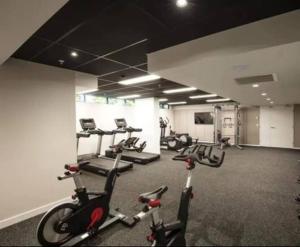 a gym with several treadmills and exercise bikes at Artistic South Brisbane 2 bedroom Apartment with Parking in Brisbane