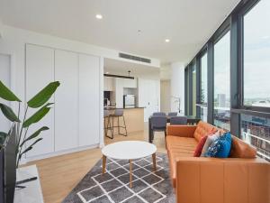 een woonkamer met een bank en een tafel bij Artistic South Brisbane 2 bedroom Apartment with Parking in Brisbane