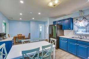 a kitchen with blue cabinets and a table and chairs at Beach House with Private Pool in North Wildwood in North Wildwood