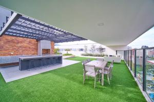 an outdoor patio with a table and chairs and grass at Moderna suite en Quito RG in Quito