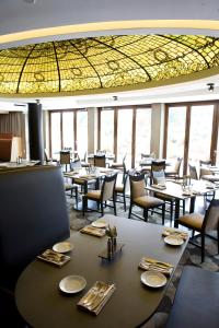 a restaurant with tables and chairs and a glass ceiling at Beechwood Hotel in Worcester