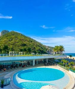 ein großer Pool neben einem Strand mit einem Berg in der Unterkunft Hotel nacional in Rio de Janeiro