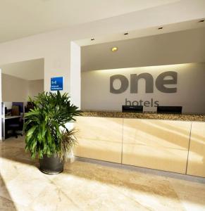 a one hotel lobby with a potted plant at One San Luis Potosi Glorieta Juarez in San Luis Potosí