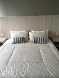 a large white bed with two pillows on it at Stampin Residence @ USS & Car (Optional) in Kuching
