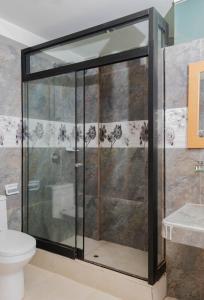 a glass shower in a bathroom with a toilet at Samay Business Hotel and Departments in Cusco