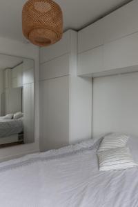 een slaapkamer met een groot wit bed en een spiegel bij Comfortable and well-appointed 30 m apartment in Vanves