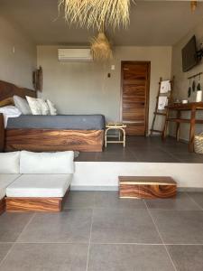een slaapkamer met een bed en een bank erin bij Mare mío Hotel Boutique in Puerto Arista
