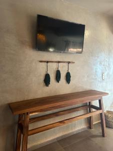 a wooden bench with taments hanging on a wall at Mare mío Hotel Boutique in Puerto Arista