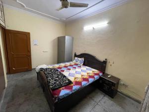 a bedroom with a bed with a checkered blanket on it at Kohli-guest house in Chandīgarh