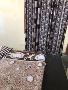 a bedroom with a bed with a pillow and a curtain at Kohli-guest house in Chandīgarh