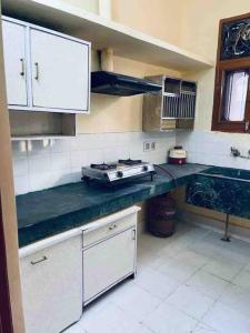 a kitchen with white cabinets and a counter top at Kohli-guest house in Chandīgarh