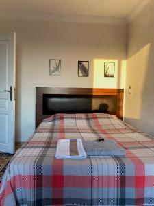 1 dormitorio con 1 cama con manta a cuadros en Spacious house near the airport en Arnavutköy