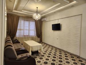 - un salon avec des chaises, une table et un écran dans l'établissement Cozy apartment 2, à Samarcande
