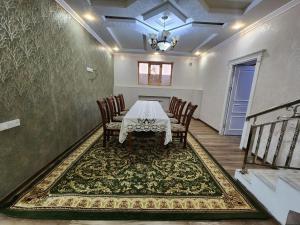 une salle à manger avec une table, des chaises et un tapis dans l'établissement Cozy apartment 2, à Samarcande