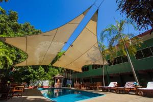 a large umbrella over a swimming pool with chairs at Hideaway Hotel in Port Moresby