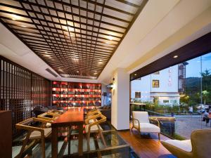 张家界Riverside Peak Lodge Zhangjiajie Wulingyuan National Park的一间设有桌椅的房间和一个图书馆