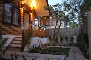a house with a staircase and a table and chairs at Gili Tempoe in Gili Trawangan
