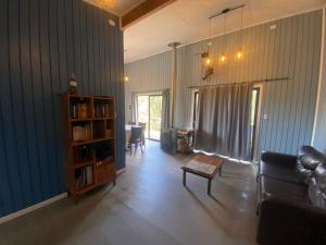 een woonkamer met een bank en een boekenplank bij Lodge Rio Mañio in Panguipulli