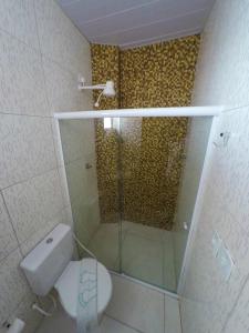 a bathroom with a glass shower and a toilet at Barra Grande Pousada in Maragogi