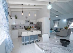 eine Küche und ein Wohnzimmer mit weißen Schränken in der Unterkunft Maison de Sérénité in Soufrière