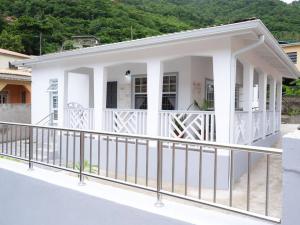 a white house with a balcony at Maison de Sérénité in Soufrière