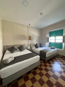 a bedroom with two beds and a checkered floor at CASA HOTEL LAS HORTENSIAS in Jardin
